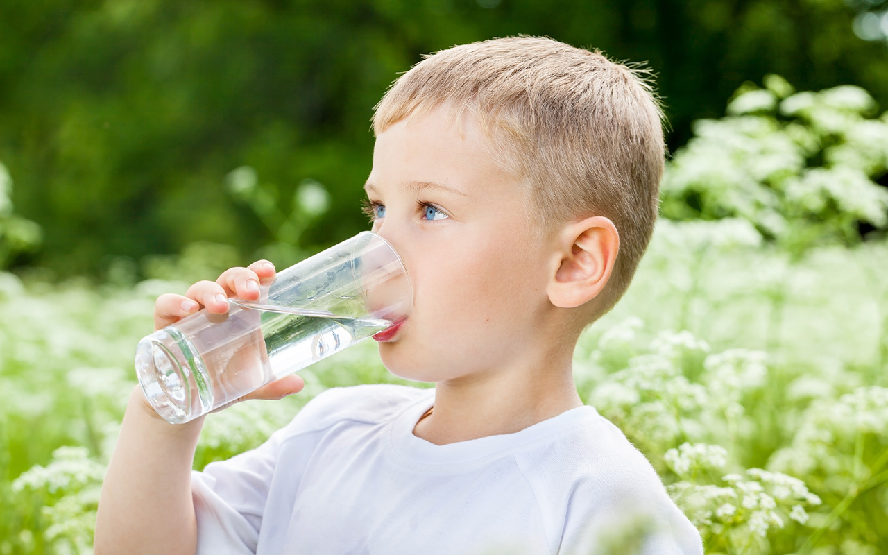 Dreng drikker et glas vand